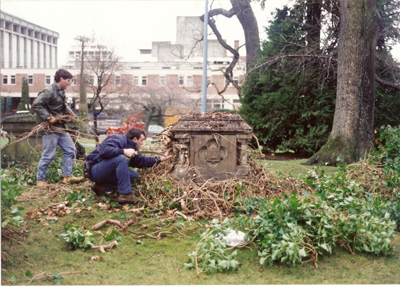 colour photo of workers cleaning a grave